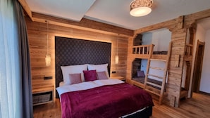 A wooden bedroom with a bunk bed, a headboard with a diamond pattern, and a hanging light fixture.