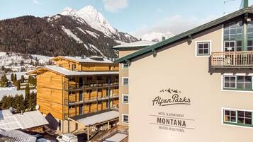 Un hotel llamado Alpen Parks con vistas a montañas nevadas.