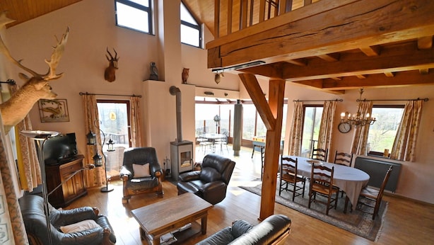 A spacious living area with a fireplace, leather sofas, and a dining table. - Holiday Home in Noiseux With BBQ Terrace (Somme-Leuze)