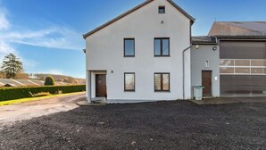 A modern two-story house with a garage, a driveway, and a well-maintained lawn. - Holiday Home in Leglise With Garden (Léglise)