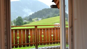 A wooden deck with a view of a green field and mountains in the distance. - Chalet in Kotschach by Ski Slopes (Kotschach-Mauthen)