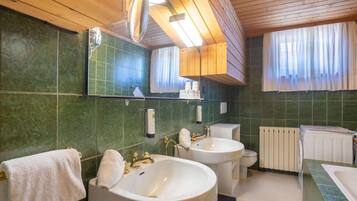 Ein Badezimmer mit zwei Waschbecken, einer Toilette und einem Spiegel.