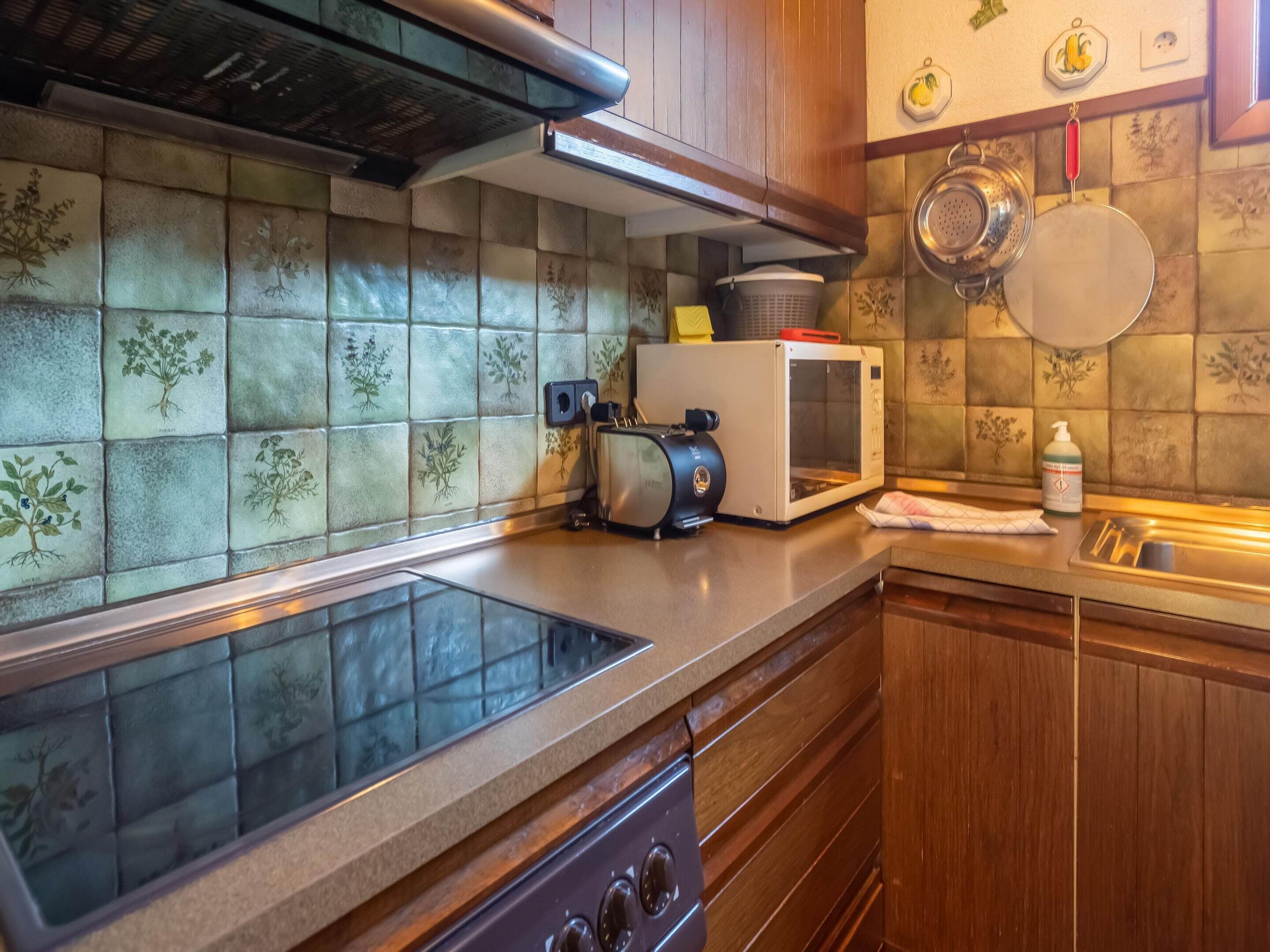 Una cocina equipada con estufa integrada, microondas y tostadora.