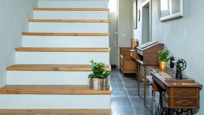 A staircase with wooden steps and two potted plants on the landing.