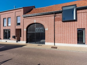 A brick building with a large arched entrance and a sign reading "tVlyt Wellness B&B". - Holiday Home in Vlijtingen With Sauna (Riemst)
