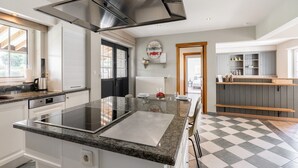 A modern kitchen with a central island, black cabinets, and a checkered floor. - Alken Farm Stay With Terrace (Alken)