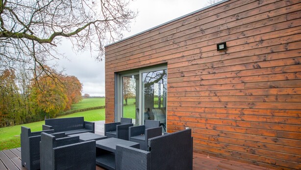 A modern outdoor patio with wicker furniture and a wooden deck. - Holiday Home in Waimes With Garden (Waimes)