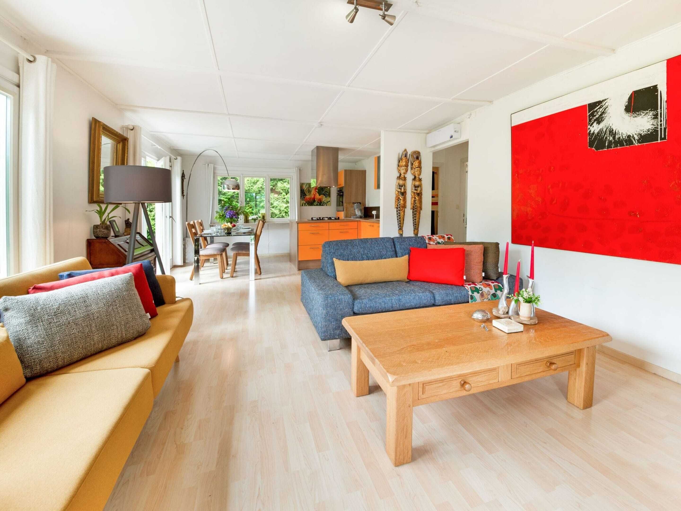 A spacious living room with a sofa, a coffee table, and a dining area with a table and chairs.
