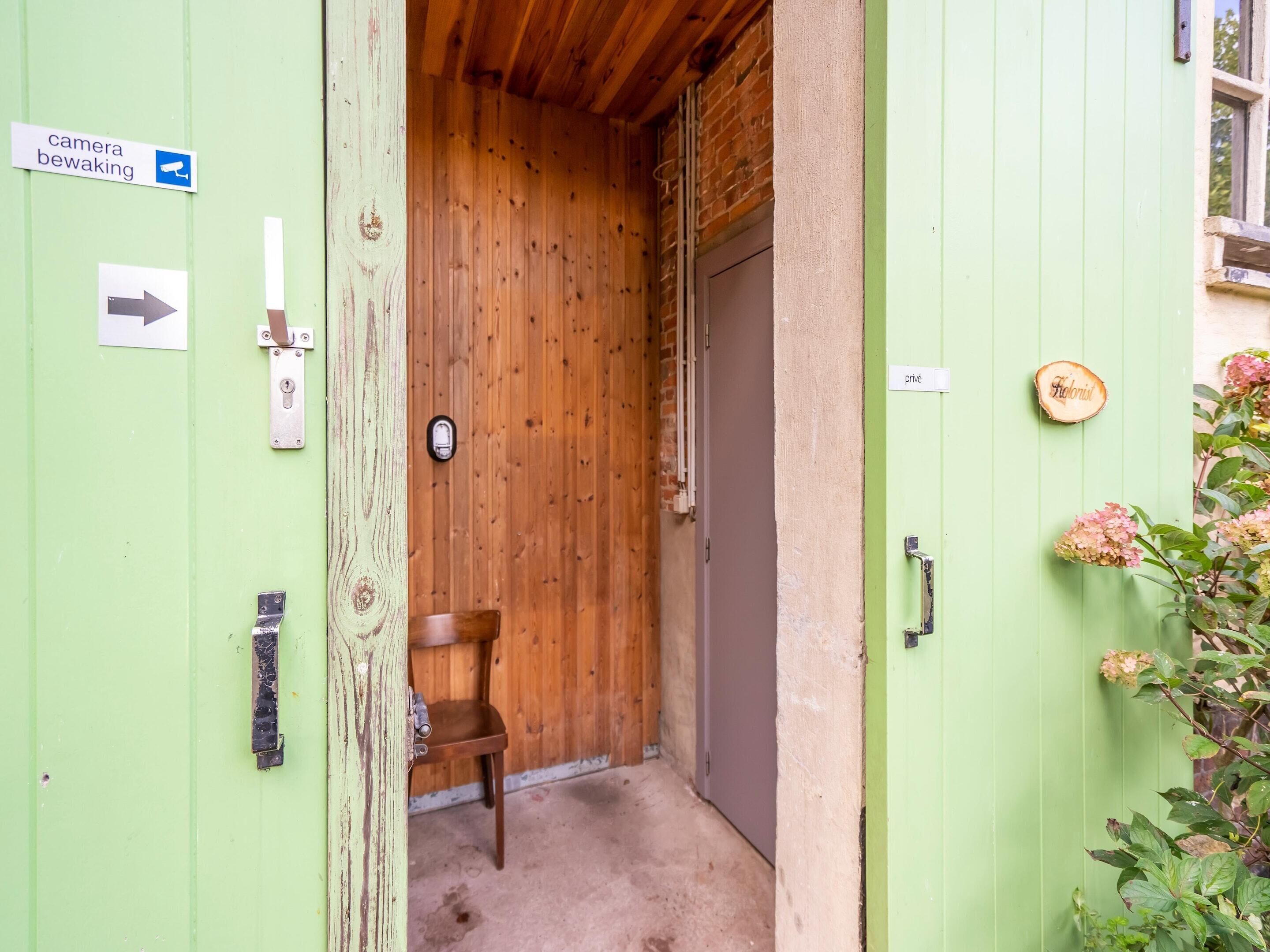 A wooden door with a sign indicating a camera.
