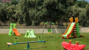 Un parque infantil con diversas estructuras de juego, como un balancín, toboganes y zonas de escalada.
