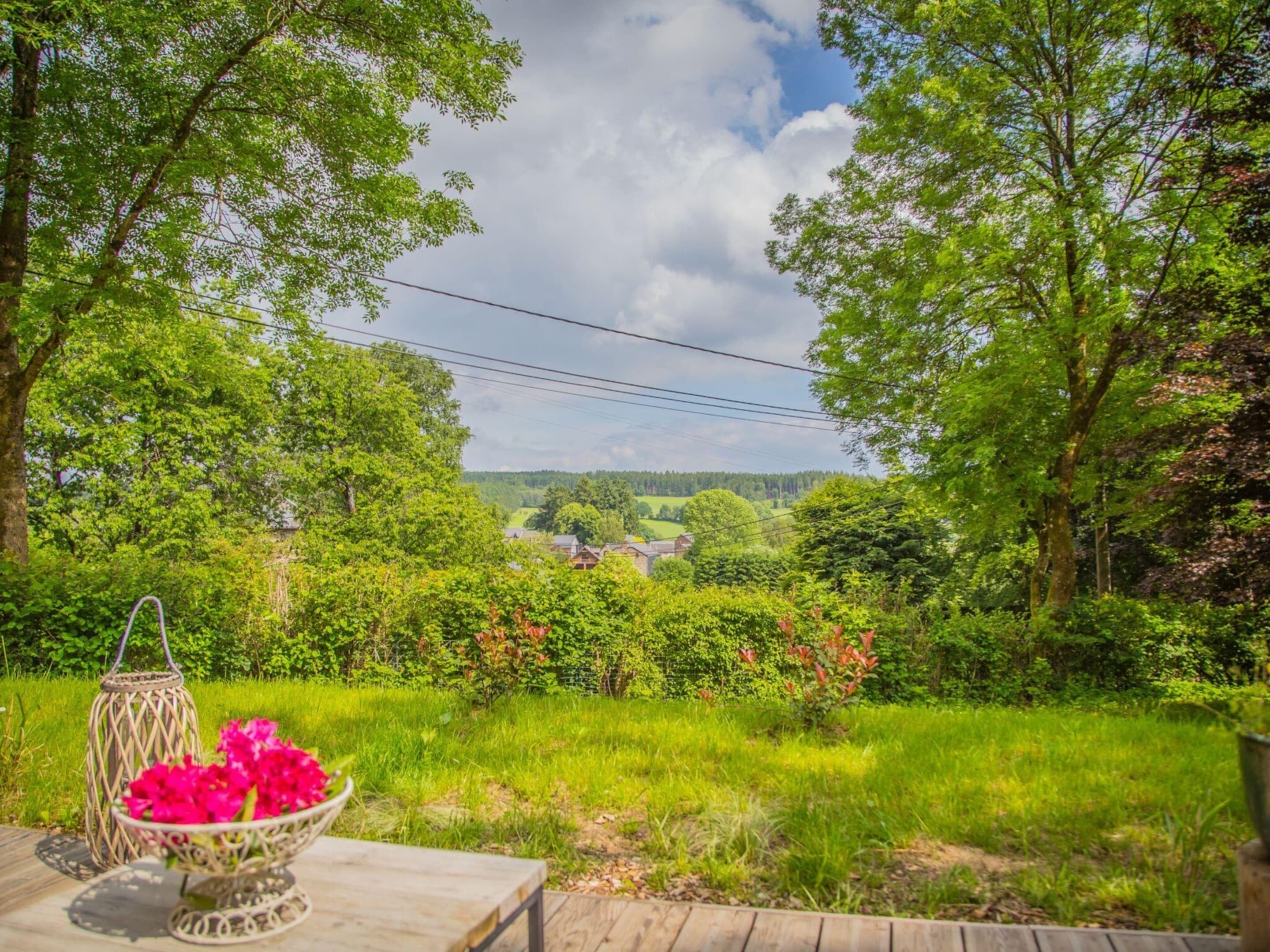 Una terraza de madera con una mesa y un farol decorativo.
