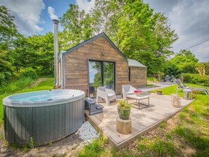 A wooden cabin with a hot tub, outdoor seating, and a deck. - Holiday Home in Ferrieres With Garden (Ferrieres)