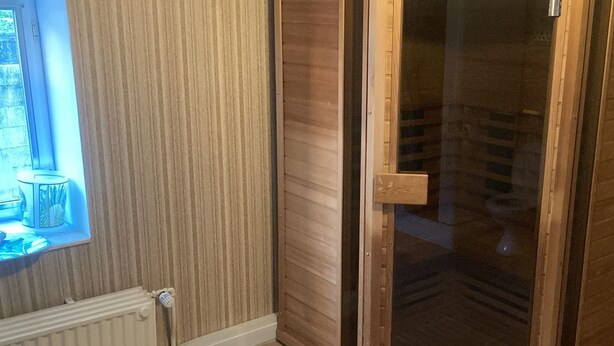 A room with a wooden door, a radiator, and a window with a view of the outdoors. - Holiday Home in Marche-en-famenne With Garden (Marche-en-Famenne)