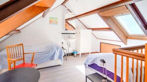 A high-ceilinged room with a skylight, a bed, a desk, a chair, and a small table. - Cozy Country Stay, Stoumont (Stoumont)