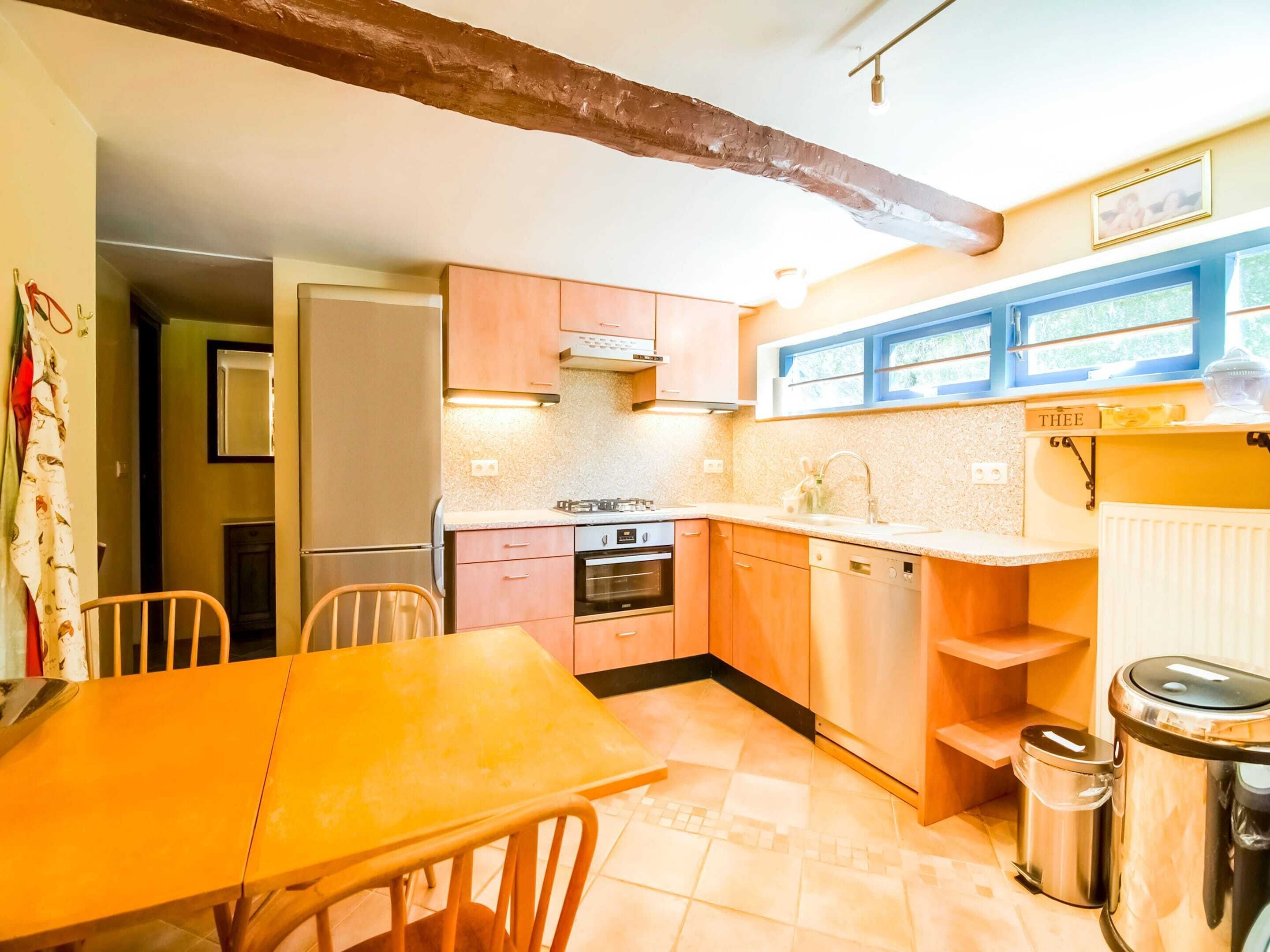 A kitchen with wooden cabinets, a gas stove, a dishwasher, and a window with a view.