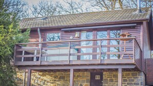 Un bâtiment en pierre de deux étages, doté d’un balcon et d’une entrée en pierre.