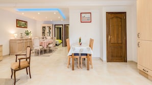 Un comedor con una mesa dispuesta para cuatro, un armario y una puerta.