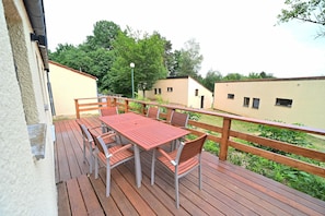 A wooden deck with a table and chairs, surrounded by a wooden railing. - Bungalow by Lake Rabais in Virton (Virton)