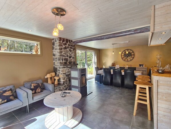 Relax in a cozy space with a central seating area, stone accent wall, and kitchen with bar stools.