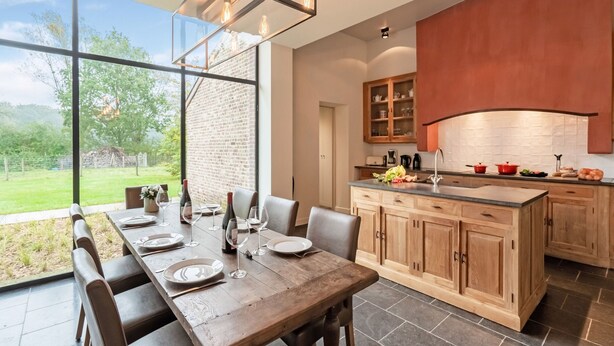 A modern kitchen with a large island, wooden cabinets, and a view of the outdoors. - Beernem Countryside Home (Beernem)
