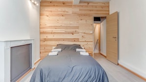 A bedroom with a bed, a wooden wall panel, a door, and a white ceiling. - Cosy Holiday Home in Hastiere With a Terrace (Hastiere)