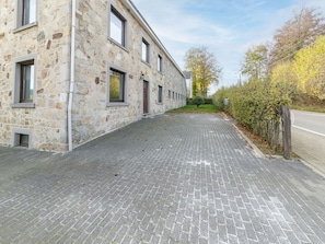 A stone building with a paved driveway leading to a gated entrance. - Farmhouse Kalys in Vielsalm With 180° View of the Forest (Vielsalm)