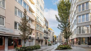 A street with modern buildings, trees, and a clear sky. - Cosy Apartment in Oostende With Private Terrace (Ostend)