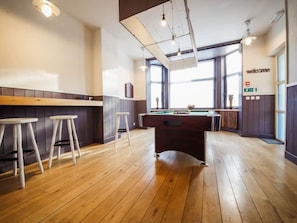Enjoy a game of pool in this spacious room with a pool table and comfortable seating.