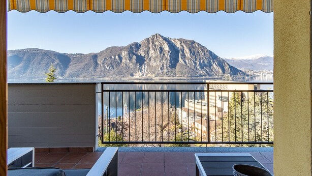A balcony with a view of a mountain and a body of water. - Wrap around Lake Views Family sized condo with large balcony (Campione d'Italia)