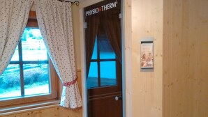 A wooden interior with a window, a door labeled "PHYSIOTHERM", and a small framed picture on the wall. - Holiday Home in Bad Kleinkirchheim (Bad Kleinkirchheim)