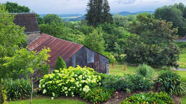 A rustic barn surrounded by lush greenery and a variety of plants. - Holiday Home in Borlon With Terrace (Durbuy)