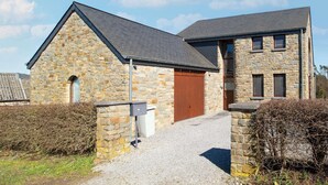 A stone building with a sloped roof and a wooden door. - Holiday Home in Borlon With Terrace (Durbuy)