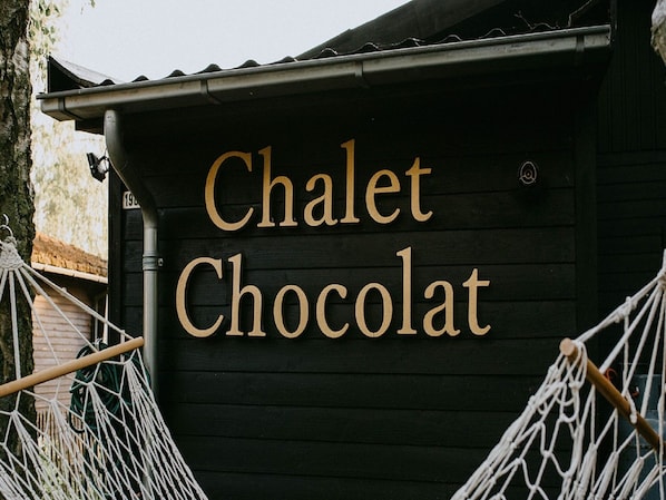 En træbygning med skiltet "Chalet Chocolat" på facaden.