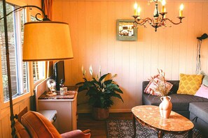 A cozy living room with a sofa, a table, a lamp, and a potted plant. - Beautiful Romantic Chalet in Geel (Geel)