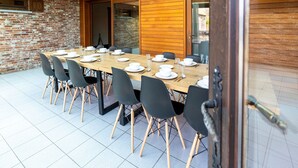 A dining area with a long wooden table set for a meal, surrounded by black chairs. - Beautiful Holiday Home in Merksplas With Garden (Merksplas)