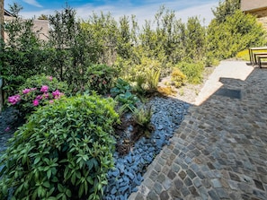 Een tuin met diverse planten en een geplaveid pad.