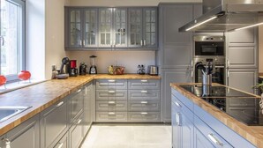 A modern kitchen with grey cabinets, a wooden countertop, and stainless steel appliances including an oven and a stove. - Charming Rural Retreat (Gedinne)