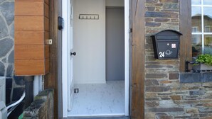 A doorway leading into a room with a stone wall and a mailbox on the right. - Rochehaut Hideaway With Tub (Bouillon)