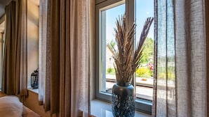 A room with a large window, a vase with dried branches, and a sofa. - Luxury Stay; La Croix Scaille (Gedinne)