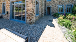 A stone building with large windows and a paved courtyard. - Luxury Stay; La Croix Scaille (Gedinne)