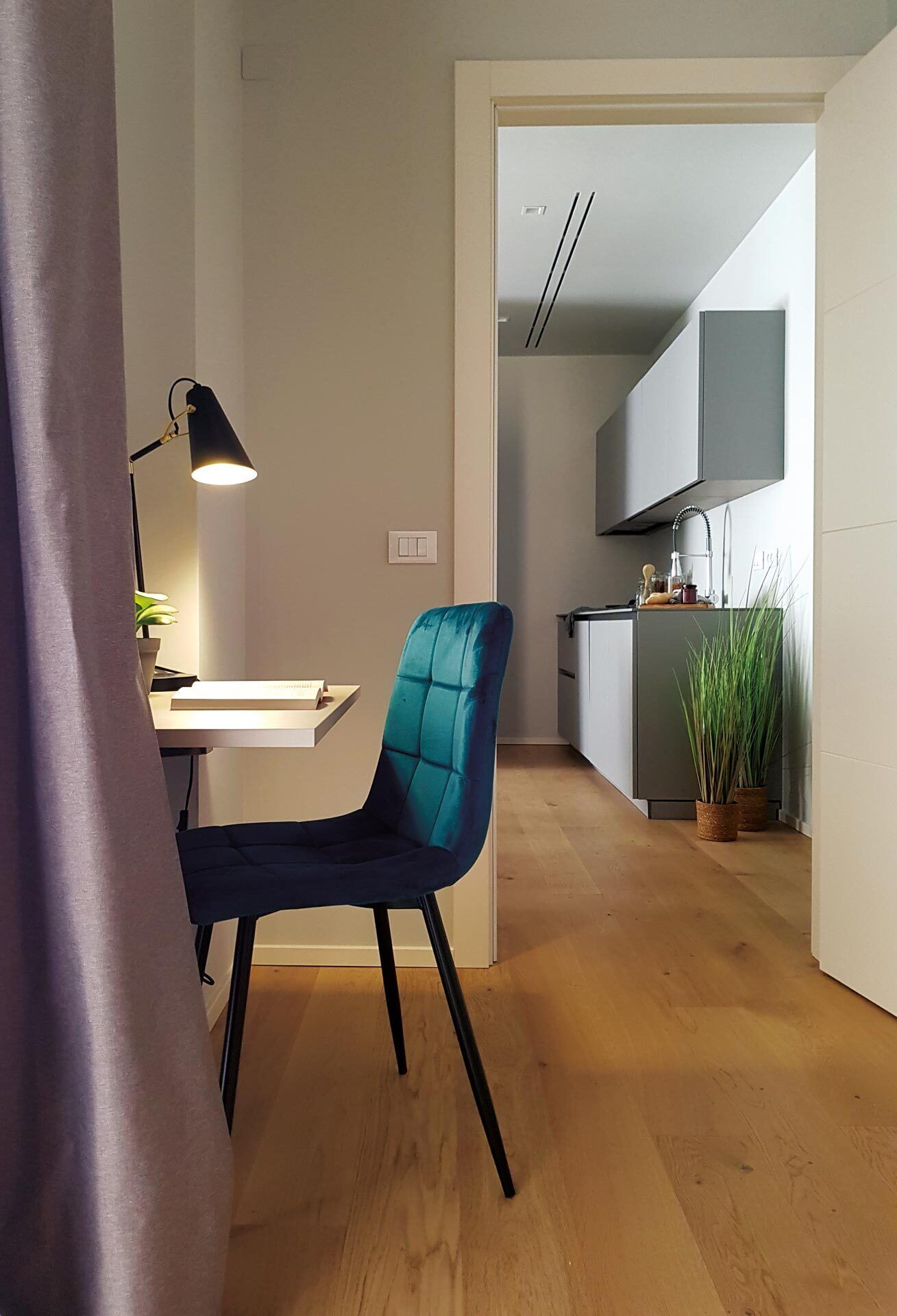 A modern kitchen with grey cabinets, a built-in oven, and a countertop with a sink.