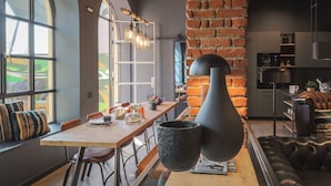 Une cuisine moderne avec un mur en briques, des plans de travail en bois et un luminaire suspendu.