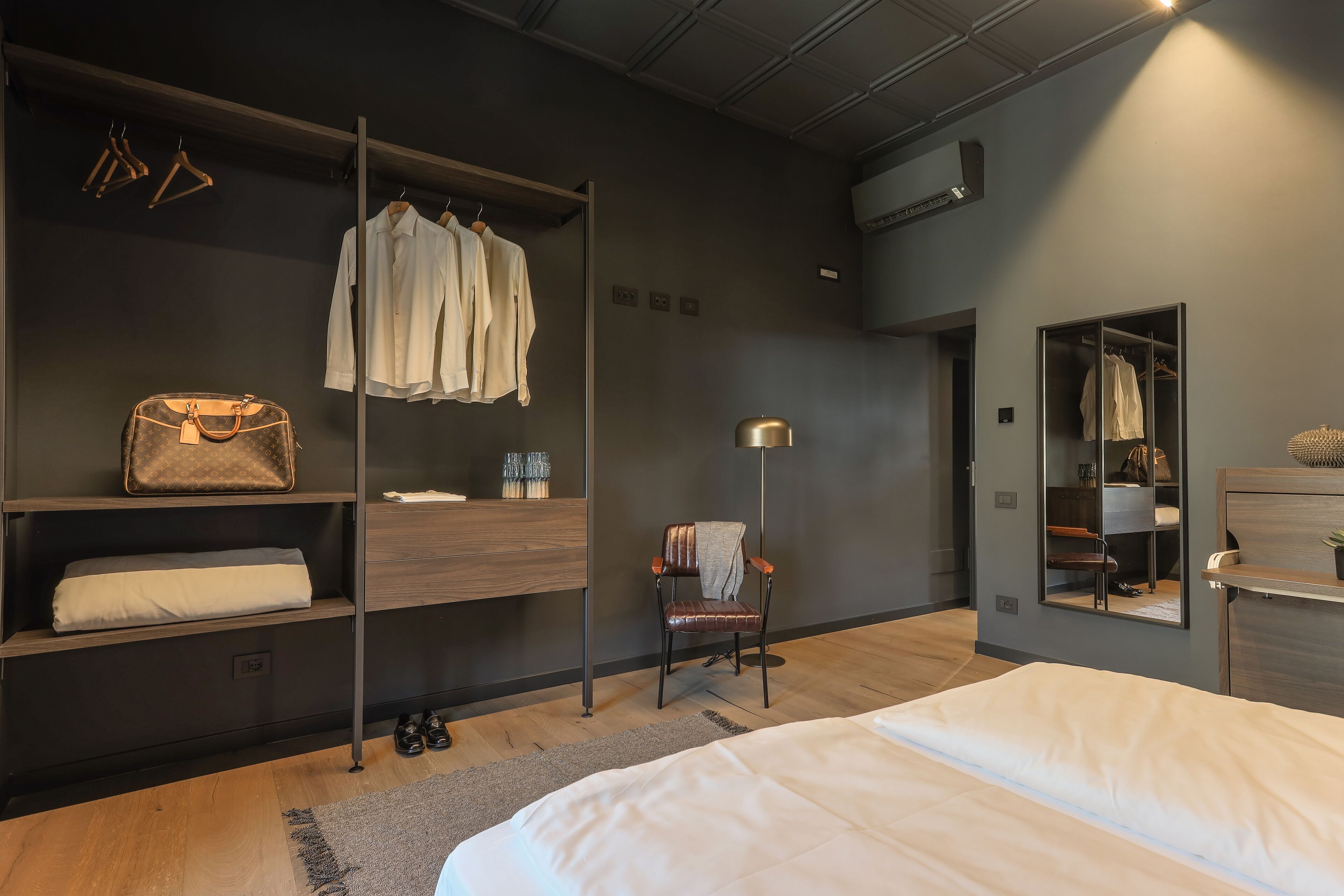 Une chambre à coucher moderne avec un lit, une armoire, une chaise et un miroir.