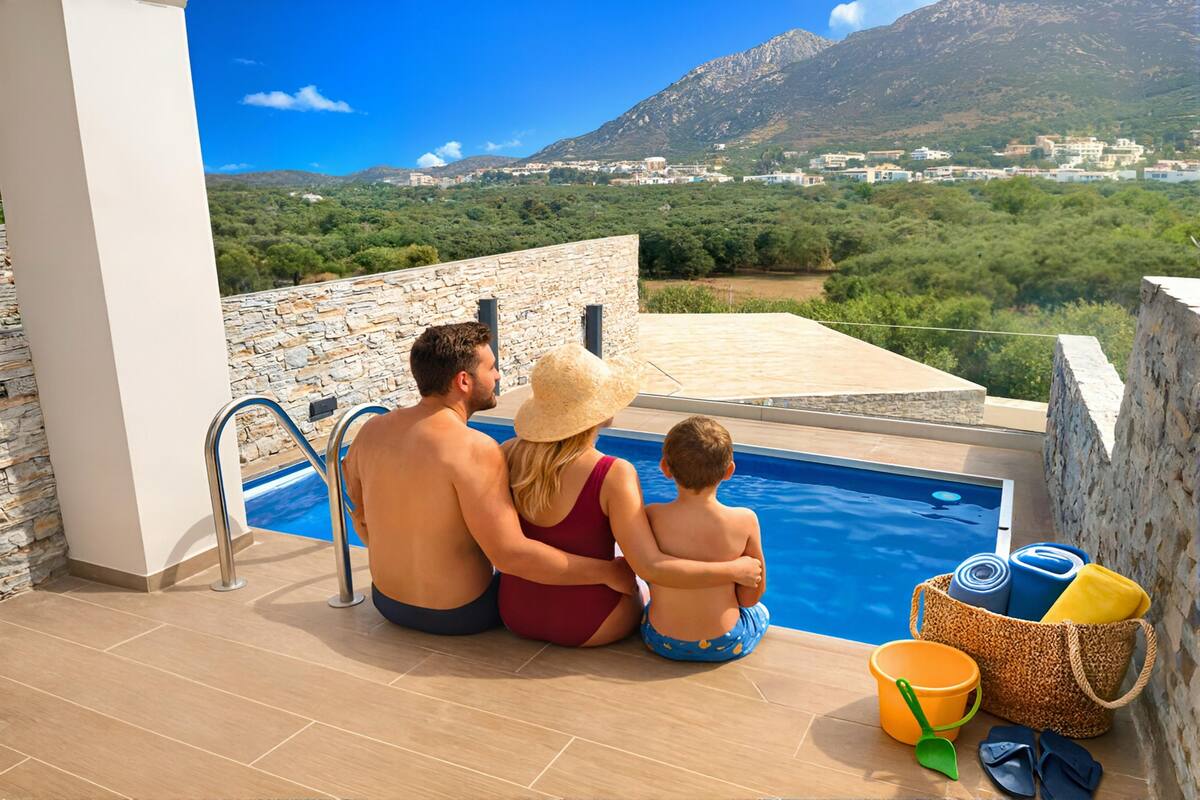 A couple and a child by a pool with a view of a mountainous landscape.