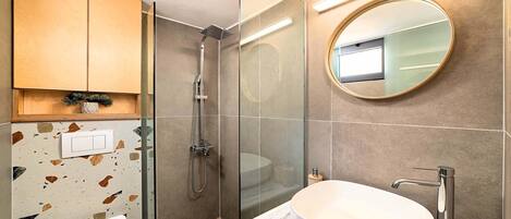 Un baño moderno con ducha, inodoro y lavabo.