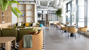 A modern interior with a sofa, chairs, a table, and a bookshelf. - Noli Malmi (Helsinki)