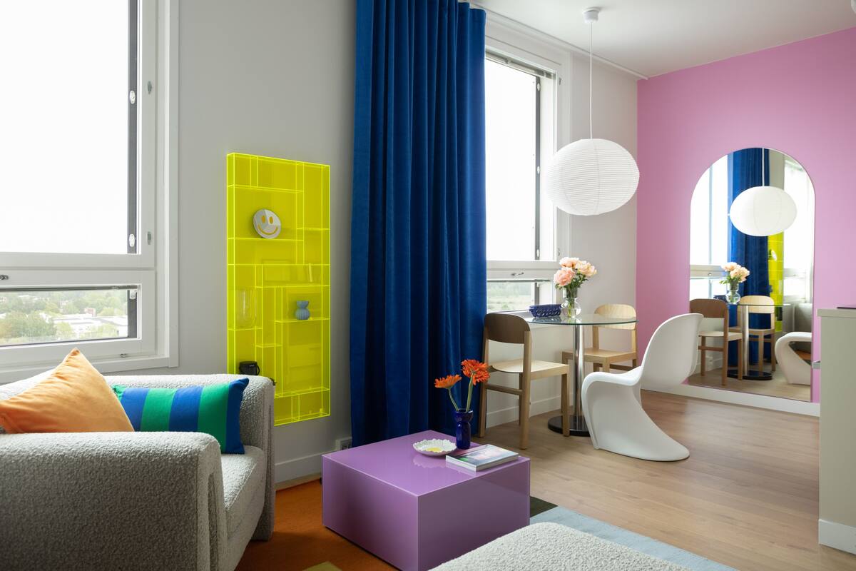 Uma sala de estar moderna com sofá, mesa de centro e área de jantar com cadeiras e mesa.