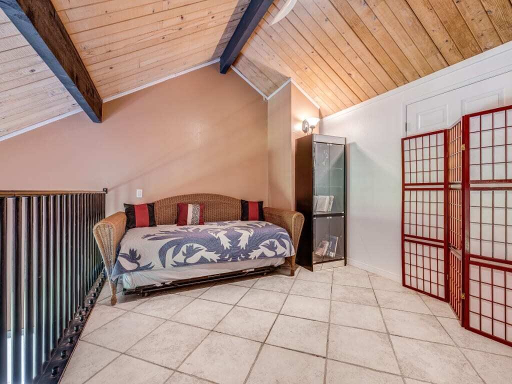 A bedroom with a bed, a wardrobe, and a sliding door.