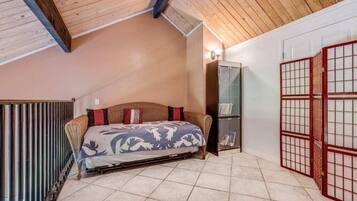 A bedroom with a bed, a wardrobe, and a sliding door.