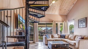 A spacious living area with a modern staircase, a sectional sofa, and a coffee table.